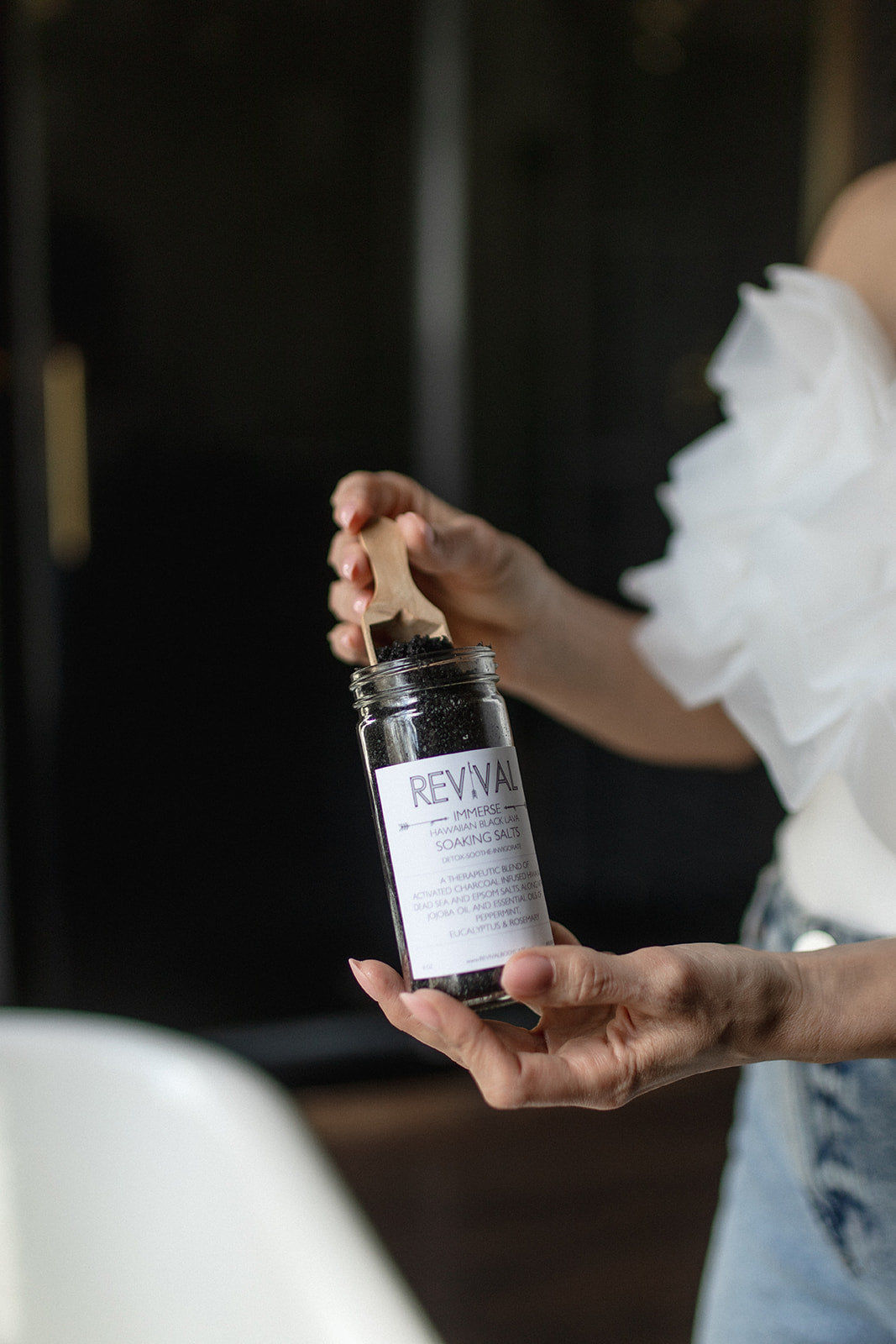 Person holding a Reviva skincare product with a blurred background