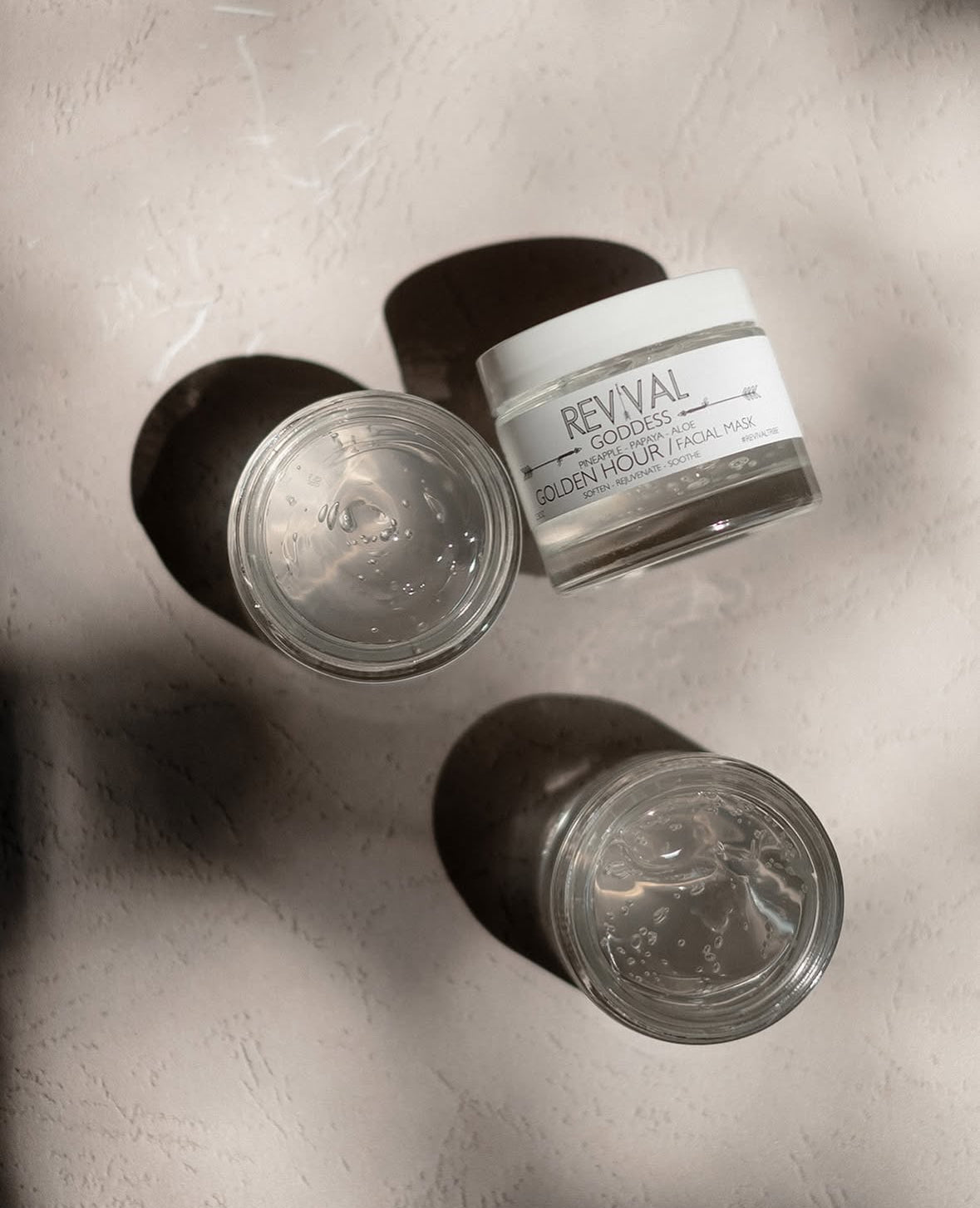 Two jars of Revival Golden Hour Facial Masks on a textured surface