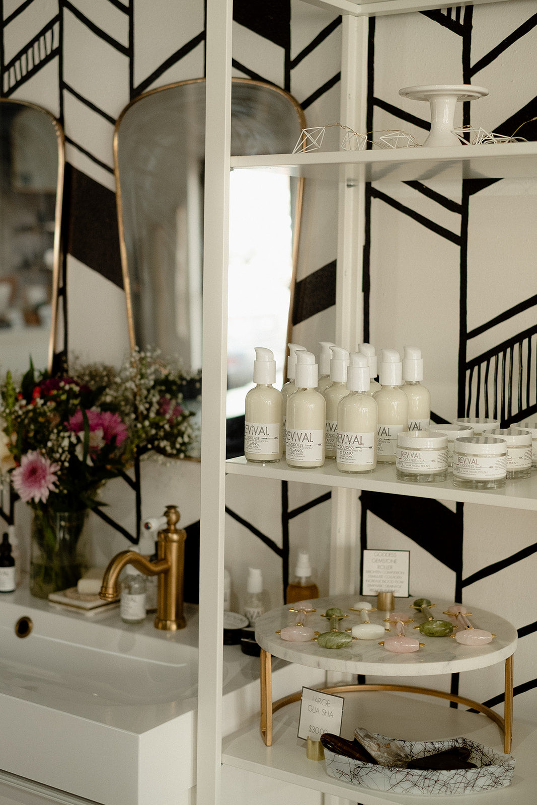 Display of Revival skincare products on a shelf with decorative elements in a stylishly decorated room.