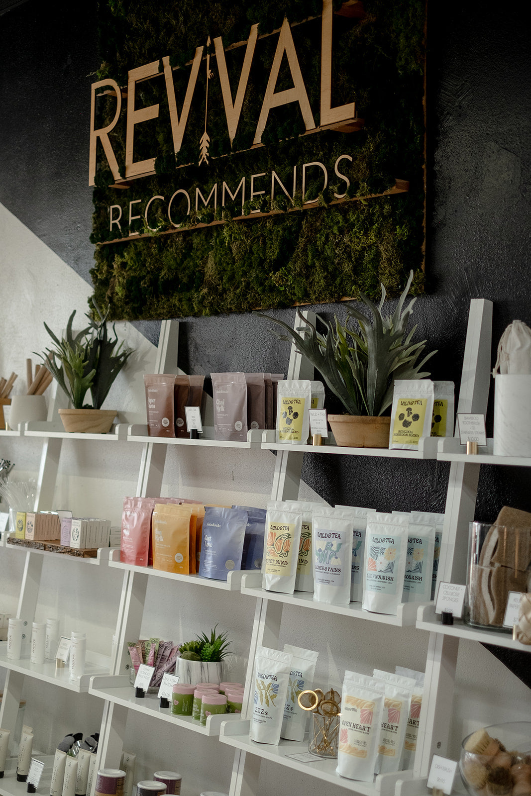 Shelves with products and a sign that reads 'Revival Recommends' in a store setting.