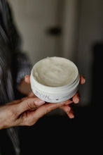 Person holding a jar Revival Lush Locks with a blurred background