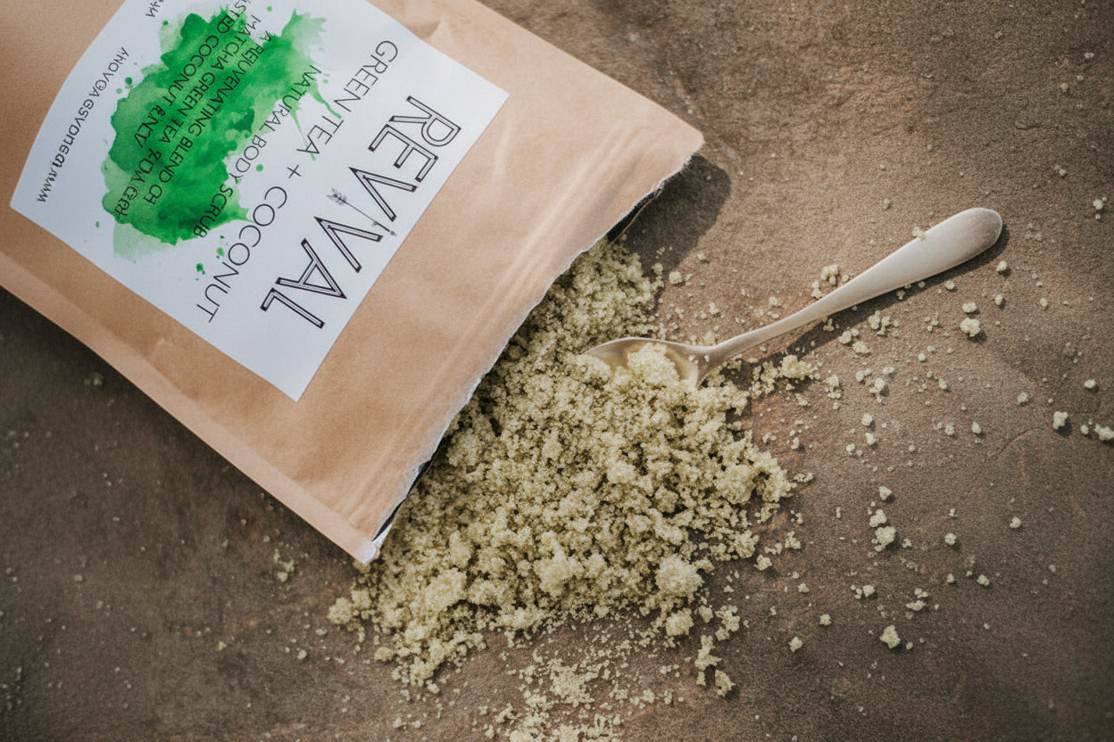A spilled open bag of Revival body scrub with green tea and coconut, with the contents partially scattered on the floor.
