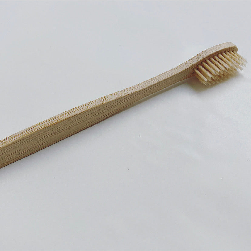 A single bamboo toothbrush with soft bristles on a white background.