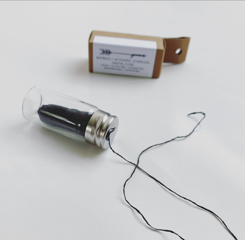 dental floss pulled out of a glass bottle 